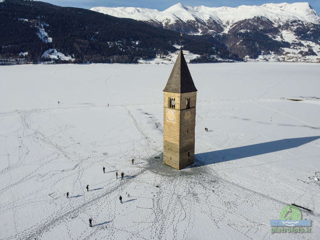 Il campanile sommerso del lago di Resia con la neve visto dal drone