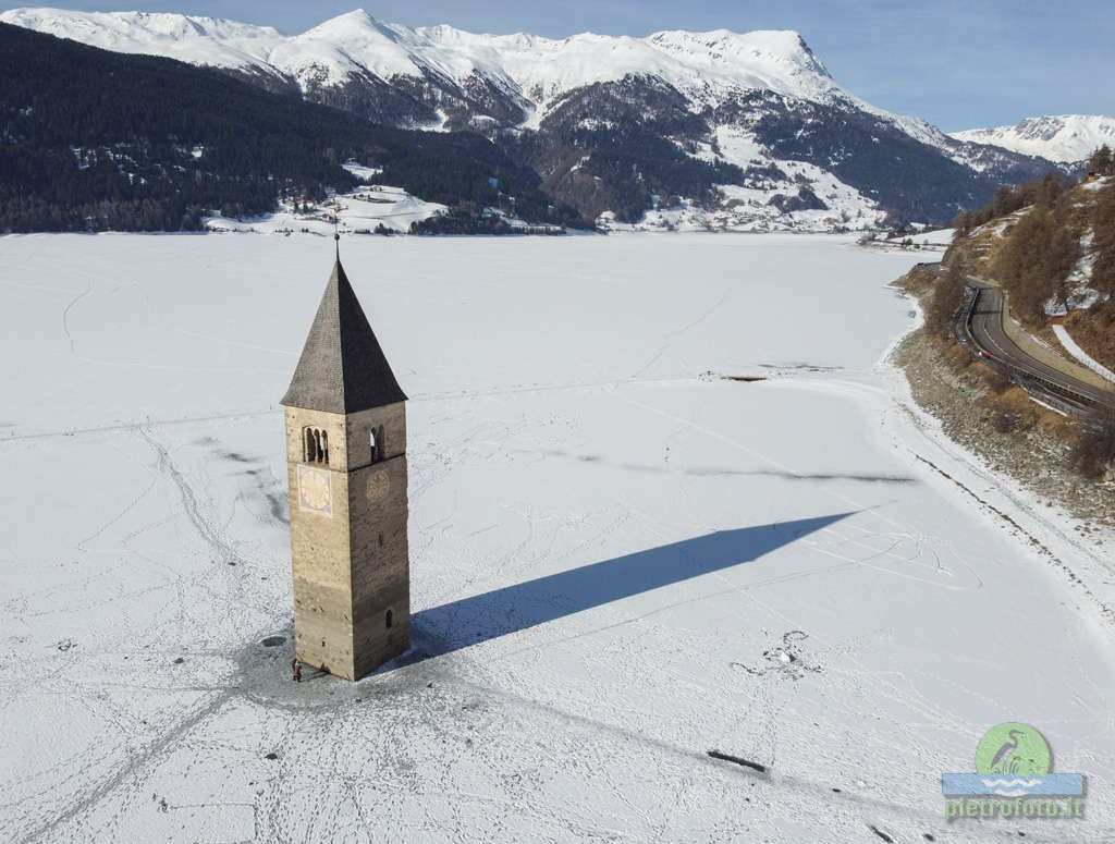 Il campanile sommerso del lago di Resia con la neve visto dal drone