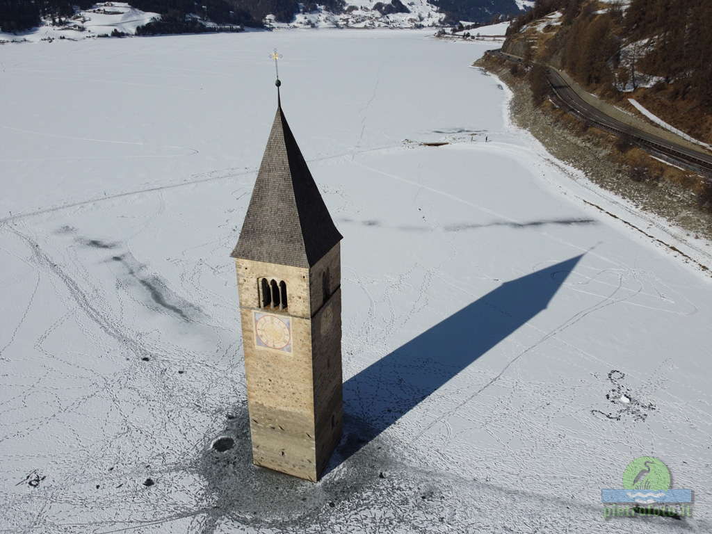Il campanile sommerso del lago di Resia con la neve visto dal drone